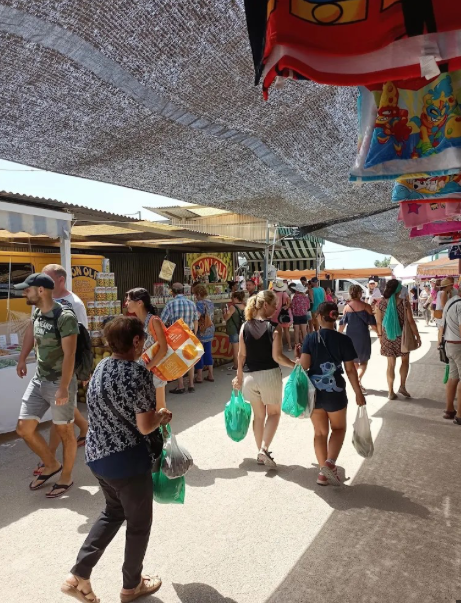 Drukbezochte buitenmarkt met kraampjes en bezoekers