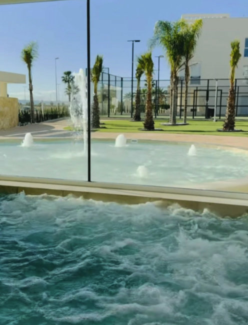 Verwarmd binnenbad met jacuzzi en zicht op het buitenzwembad en complex